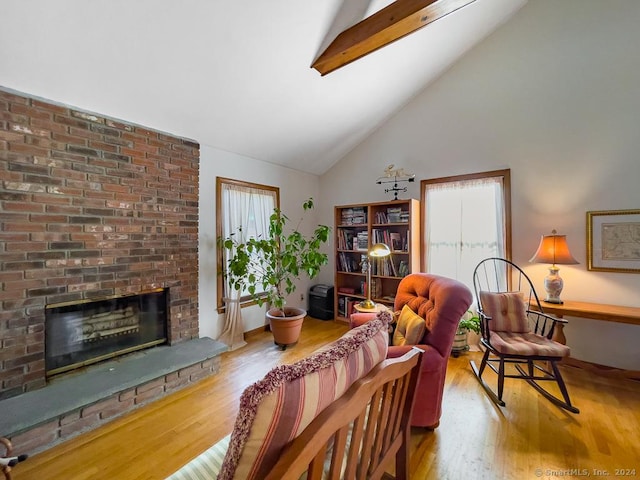 living room featuring beam ceiling, a brick fireplace, high vaulted ceiling, and hardwood / wood-style flooring