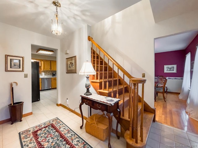 stairway with a chandelier and wood-type flooring