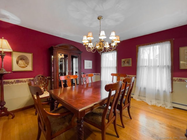 dining space featuring light hardwood / wood-style flooring and an inviting chandelier