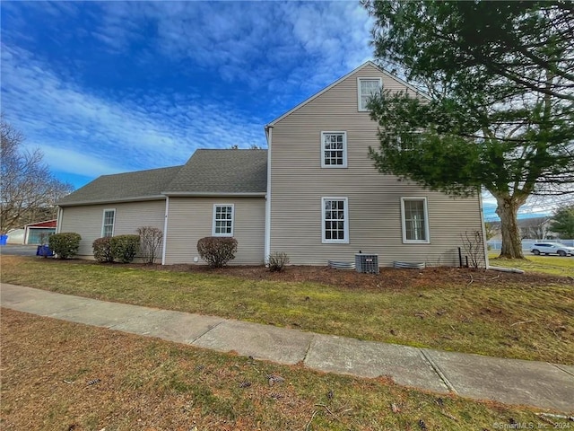 view of property exterior featuring central AC and a lawn