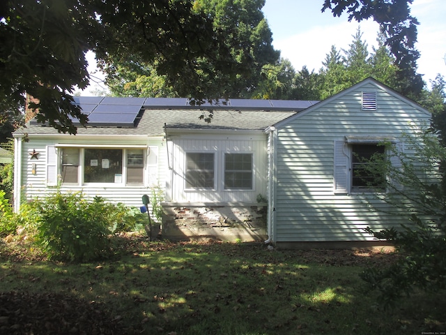 exterior space featuring solar panels and a front yard