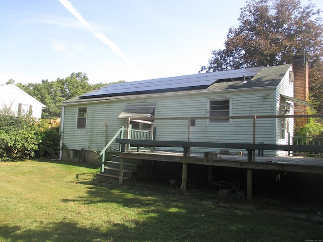 rear view of house featuring a yard and a wooden deck