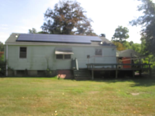 rear view of house featuring a yard