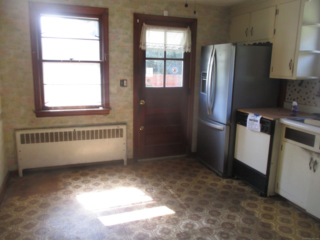 kitchen featuring dishwasher, stainless steel fridge, and radiator heating unit