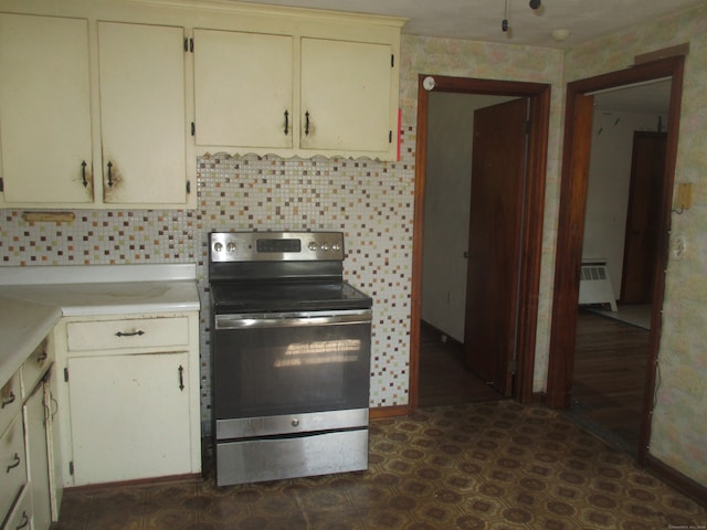 kitchen with electric stove, cream cabinetry, and radiator heating unit