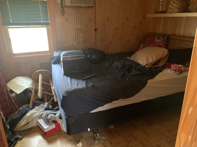 bedroom featuring an AC wall unit and parquet flooring