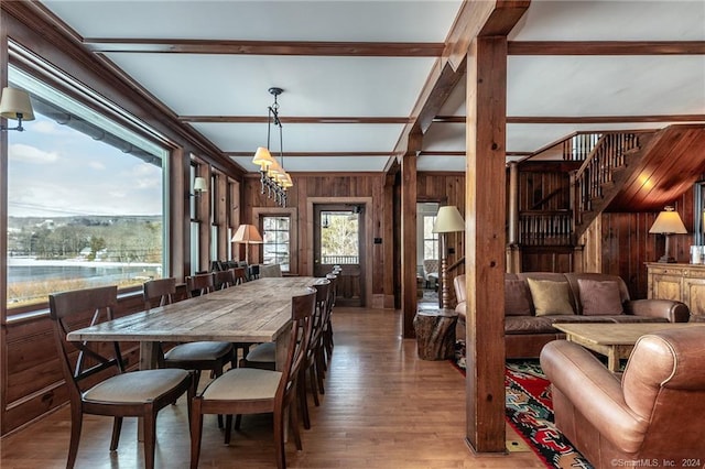 dining area featuring an inviting chandelier, hardwood / wood-style flooring, and wood walls