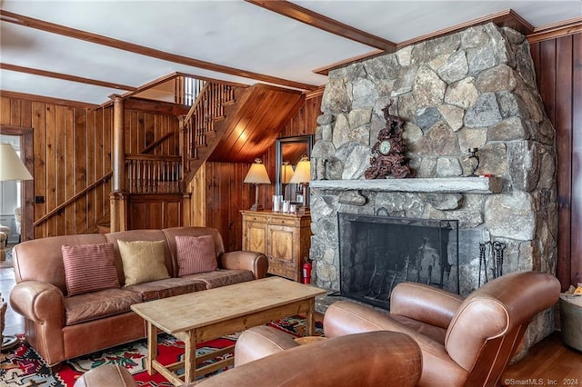 living room featuring wood-type flooring, wooden walls, and a stone fireplace