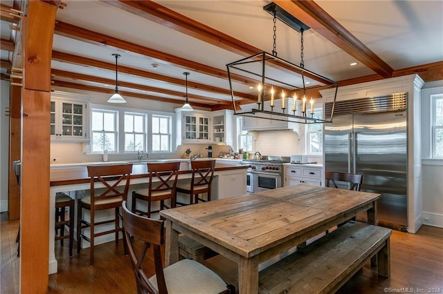 dining area featuring beamed ceiling and wood-type flooring