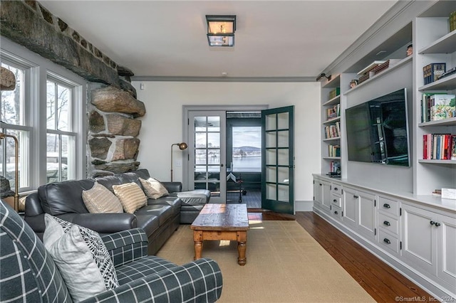 living room with crown molding, french doors, dark hardwood / wood-style flooring, and a healthy amount of sunlight