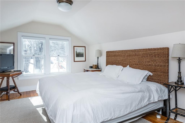 bedroom featuring hardwood / wood-style floors and vaulted ceiling