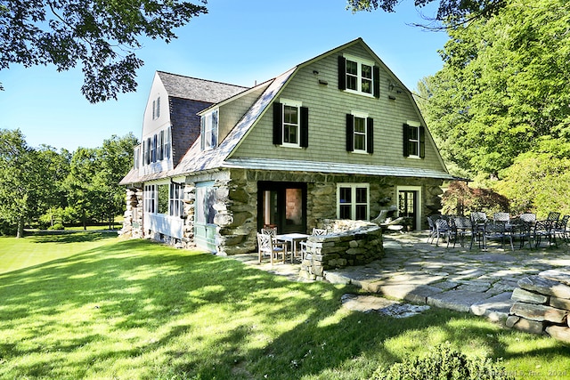 rear view of house with a yard and a patio