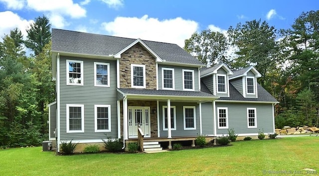 rear view of house with a lawn, central AC unit, and a porch