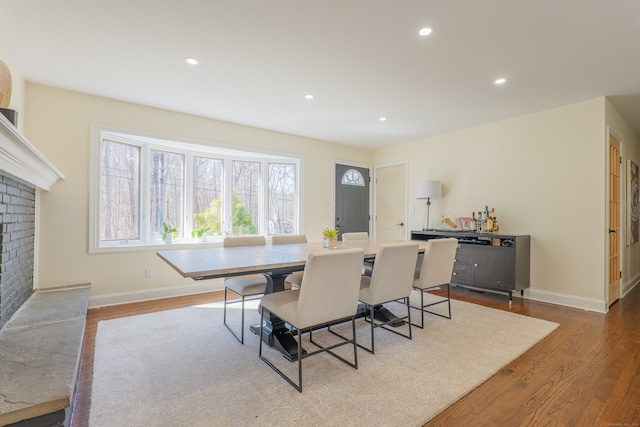 dining space with light wood-type flooring and a fireplace