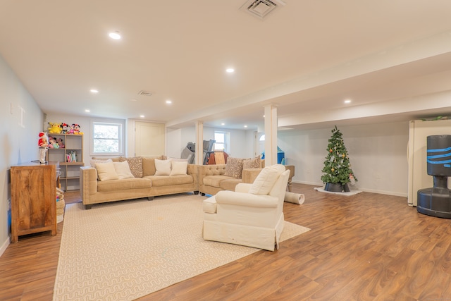 living room featuring ornate columns and light wood-type flooring