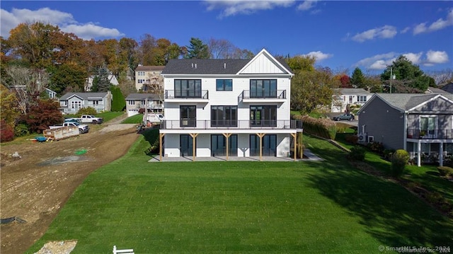 rear view of property featuring a yard and a patio