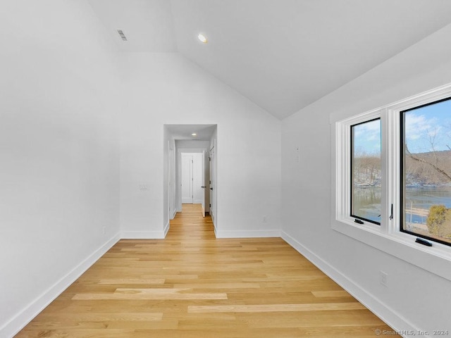 corridor featuring light hardwood / wood-style floors and lofted ceiling