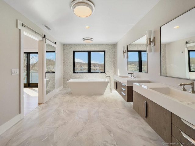 bathroom with a washtub and vanity