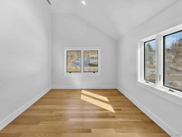 empty room featuring vaulted ceiling and light hardwood / wood-style flooring