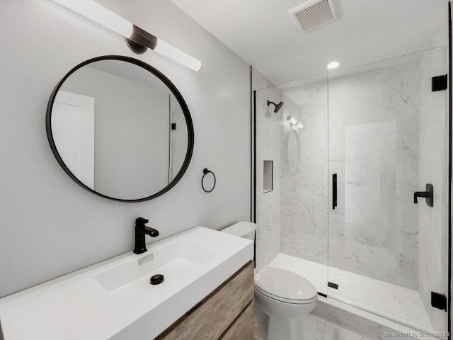 bathroom with toilet, a shower with door, and vanity