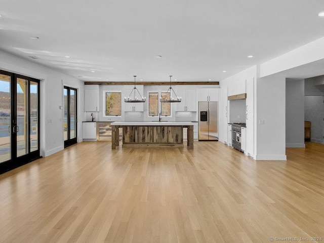 kitchen featuring white cabinetry, appliances with stainless steel finishes, french doors, pendant lighting, and a center island