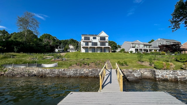 view of dock with a water view and a yard