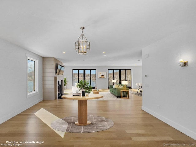 interior space featuring light wood-type flooring, a chandelier, and french doors