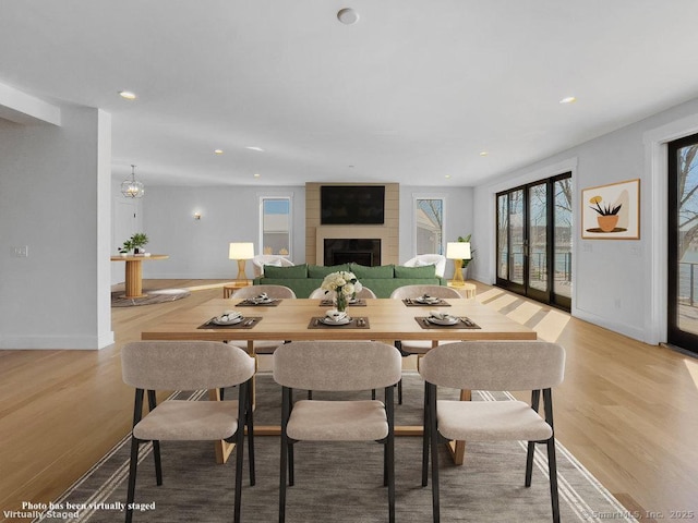 dining space with light hardwood / wood-style floors and a fireplace