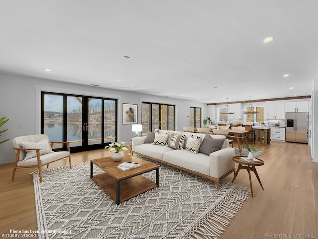 living room with light wood-type flooring and french doors