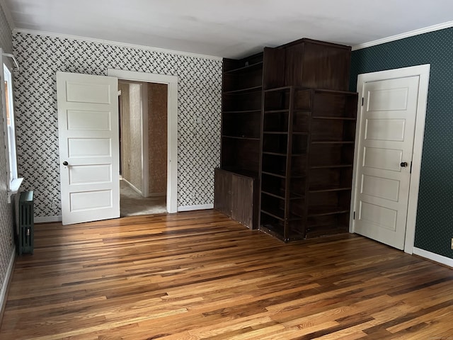 unfurnished bedroom featuring hardwood / wood-style flooring, ornamental molding, and radiator heating unit