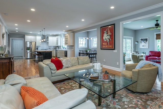 living room featuring a healthy amount of sunlight, light hardwood / wood-style floors, and ornamental molding