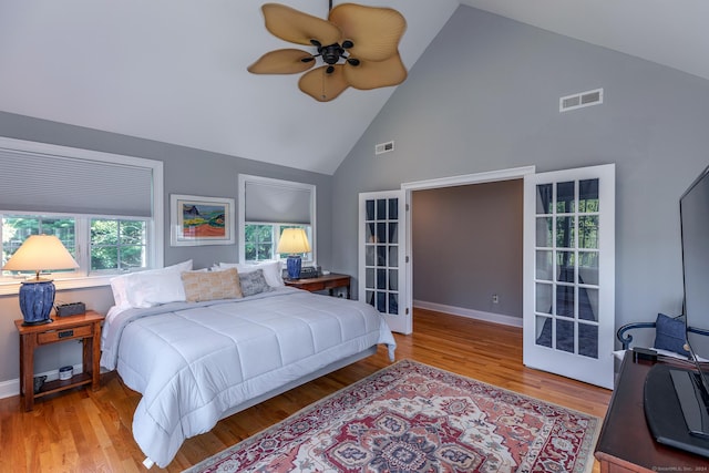 bedroom with ceiling fan, light wood-type flooring, and high vaulted ceiling