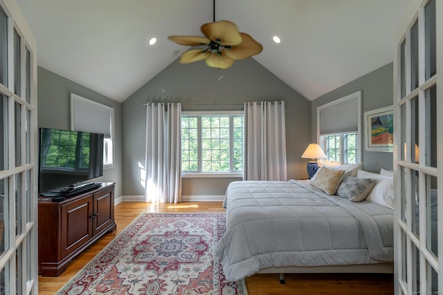 bedroom with lofted ceiling, ceiling fan, and light wood-type flooring