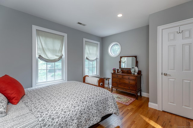 bedroom featuring light hardwood / wood-style flooring and multiple windows