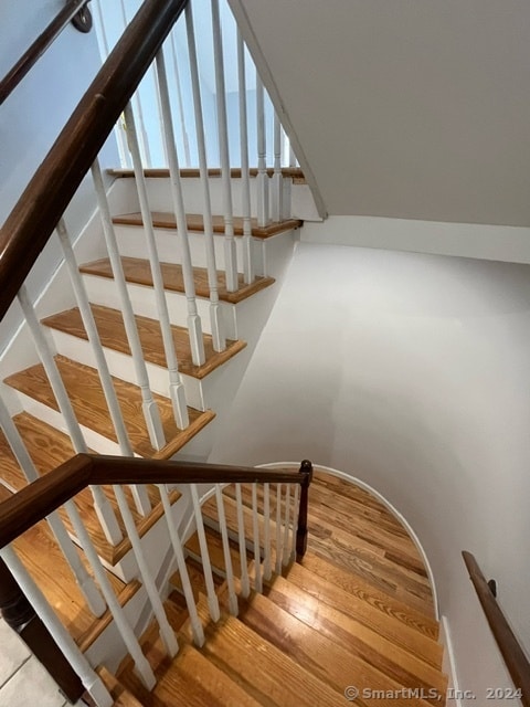 stairway with light hardwood / wood-style floors