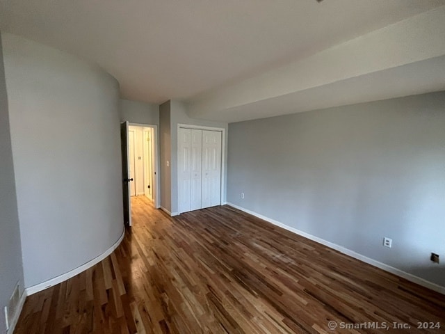 unfurnished room with dark wood-type flooring