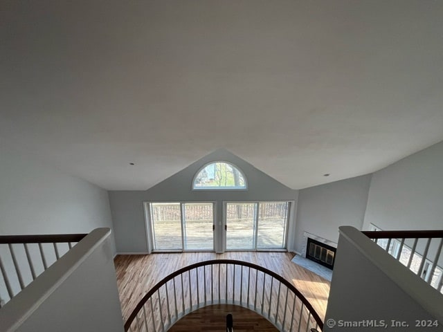 stairs featuring light hardwood / wood-style floors and vaulted ceiling