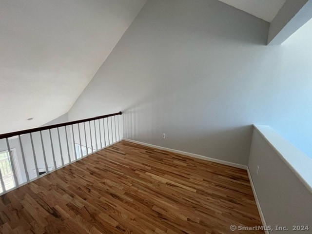 staircase featuring dark hardwood / wood-style flooring and lofted ceiling