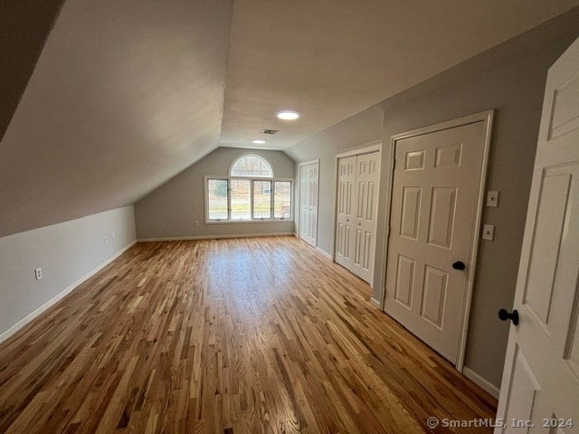 bonus room with lofted ceiling and light hardwood / wood-style floors