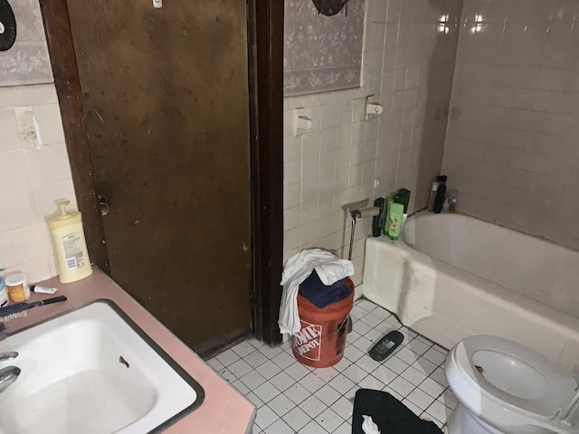 full bathroom with tile patterned floors, bathing tub / shower combination, sink, tile walls, and toilet