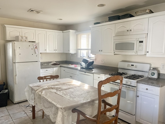 kitchen with white cabinets, light tile patterned flooring, white appliances, and sink