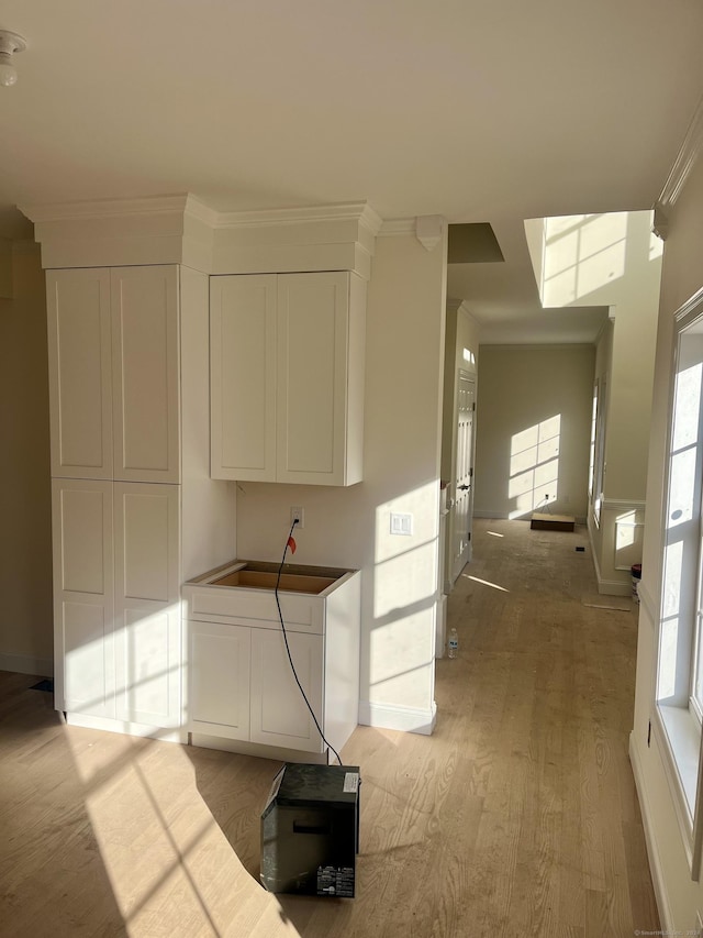 corridor featuring crown molding and light hardwood / wood-style floors