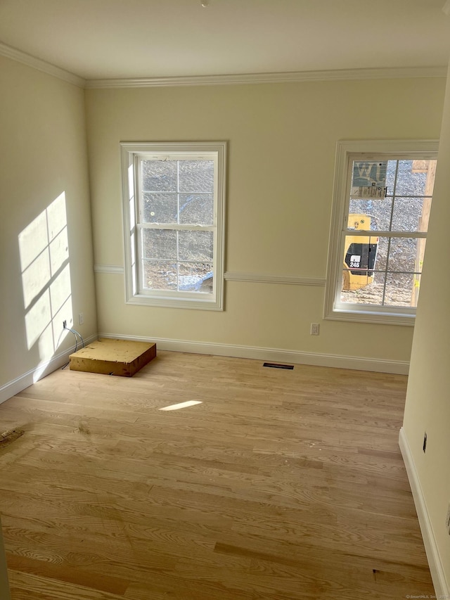 unfurnished room featuring crown molding and light hardwood / wood-style flooring