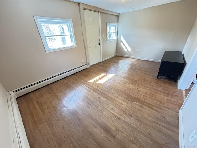 interior space with a baseboard radiator and light hardwood / wood-style floors