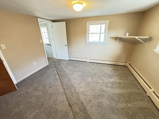 empty room with baseboard heating, carpet floors, and a textured ceiling