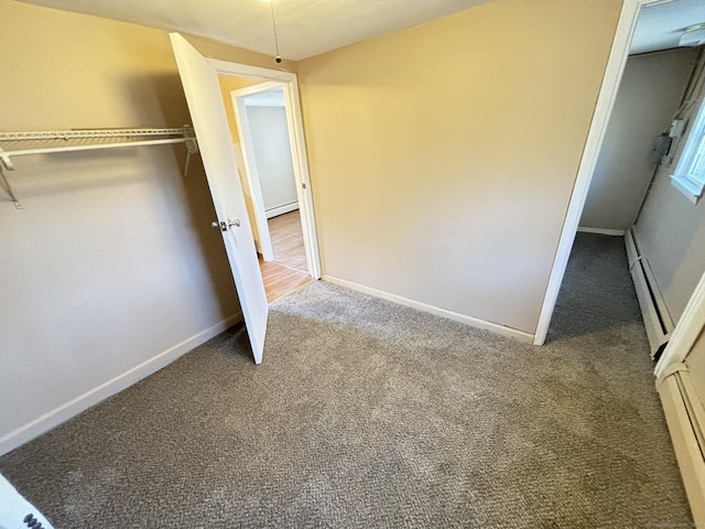 unfurnished bedroom with a baseboard heating unit and carpet flooring