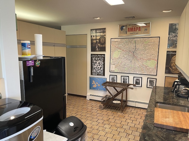 kitchen with a sink, a baseboard radiator, visible vents, freestanding refrigerator, and gray cabinets