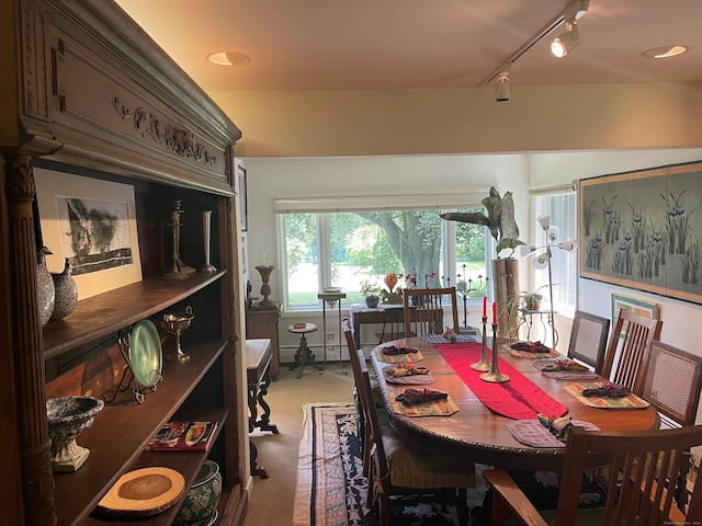 dining area with carpet floors and track lighting