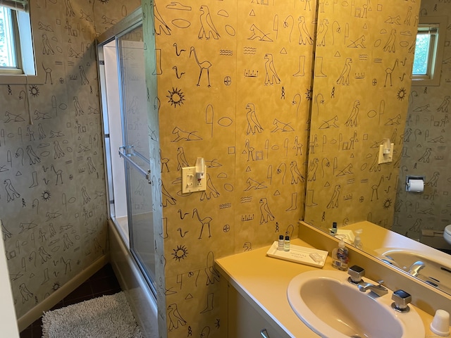 full bathroom featuring tile patterned floors, shower / bath combination with glass door, vanity, and toilet