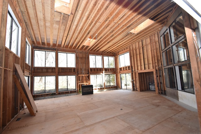 miscellaneous room with a skylight and a towering ceiling